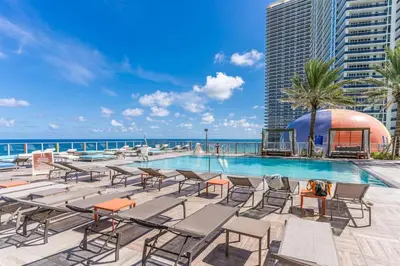 a swimming pool with chairs and a view of the ocean at HydeHotel 2BED Lux Condo Ocean View Resort in Hollywood