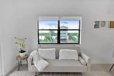 a white living room with a couch and a window at Hollywood Beachfront Apartment in Hollywood
