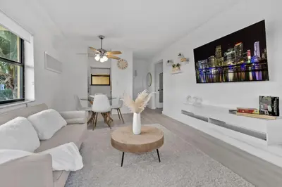 a white living room with a couch and a table at Hollywood Beachfront Apartment in Hollywood