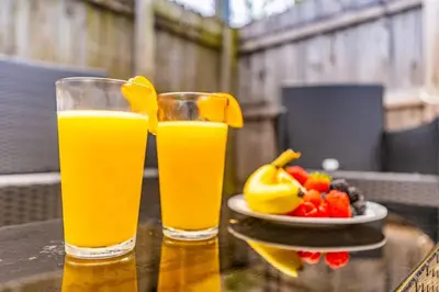two glasses of orange juice and a plate of fruit at Trendy Family Home -Heated Pool in Hollywood
