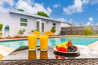 a tray of fruit and drinks next to a swimming pool at Trendy Family Home -Heated Pool in Hollywood