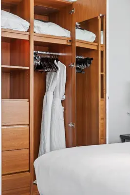 a bedroom with a bed and a white dress on a closet at THE SETAI 5 STARS HOTEL-RESIDENCE MIAMI BEACH OCEANVIEW 2 Bedroom UNIQUE in Miami Beach