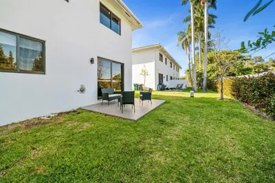 a backyard with a table and chairs on a lawn at Modern RocknHome Near Hard Rock and FLL Airport in Fort Lauderdale