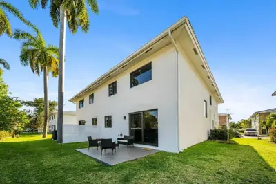 a white house with a table and chairs at Modern RocknHome Near Hard Rock and FLL Airport in Fort Lauderdale