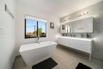 a white bathroom with a large tub and a mirror at Modern RocknHome Near Hard Rock and FLL Airport in Fort Lauderdale