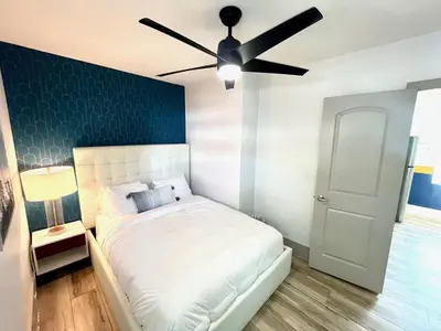 a bedroom with a white bed with a ceiling fan at Bahama Mama Las Olas and Holiday Park w Hot Tub in Fort Lauderdale