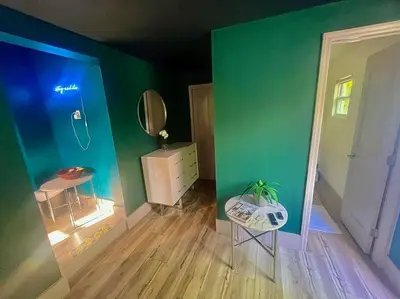 a room with a green wall and a table and a mirror at Moody Stoody-O in Las Olas Beach and Holiday Park in Fort Lauderdale