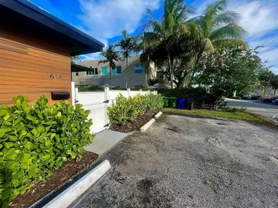 a driveway in front of a house with a white fence at Moody Stoody-O in Las Olas Beach and Holiday Park in Fort Lauderdale