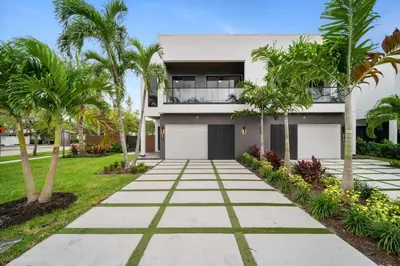 a walkway in front of a house with palm trees at The Elements Home with 2 Pools in Fort Lauderdale