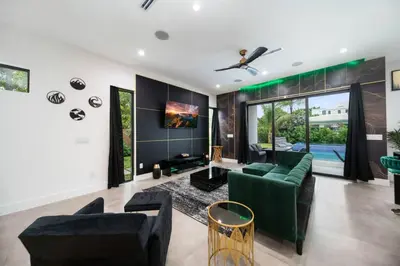 a living room with a green couch and chairs at The Elements Home with 2 Pools in Fort Lauderdale
