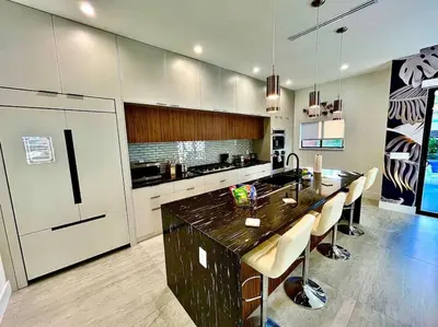 a kitchen with a large island with a counter top at Botanical Oasis Home with 2 Pools in Fort Lauderdale