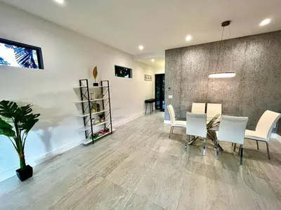 a dining room with a table and white chairs at Botanical Oasis Home with 2 Pools in Fort Lauderdale