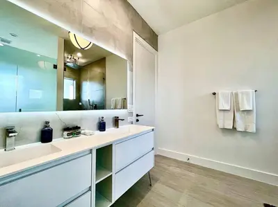 a bathroom with a sink and a large mirror at The Botanicals Las Olas Near Beach in Fort Lauderdale