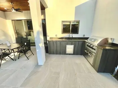 a kitchen with a table and a stove and a dining room at The Botanical Oasis Las Olas in Fort Lauderdale