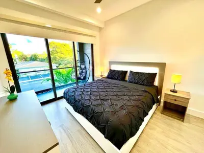 a bedroom with a large bed with a large window at The Botanical Oasis Las Olas in Fort Lauderdale