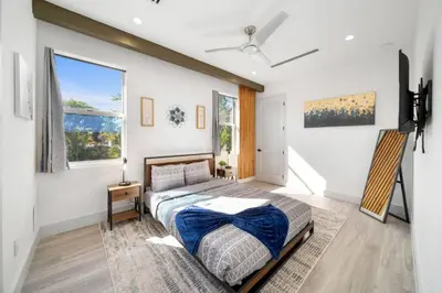 a bedroom with a bed and two windows at Las Olas Zen Home with Pool and Hot Tub Near Beach in Fort Lauderdale
