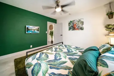 a bedroom with a bed and a green wall at Newly Renovated Tropical Oasis Near Las Olas Beach in Fort Lauderdale