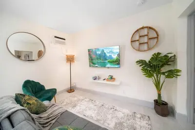 a living room with a couch and a mirror at Newly Renovated Tropical Oasis Near Las Olas Beach in Fort Lauderdale