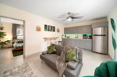a living room with a couch and a kitchen at Newly Renovated Tropical Oasis Near Las Olas Beach in Fort Lauderdale