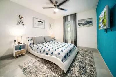 a bedroom with a large bed and a blue wall at Las Olas Newly Renovated Coastal 1BR Near Beach in Fort Lauderdale