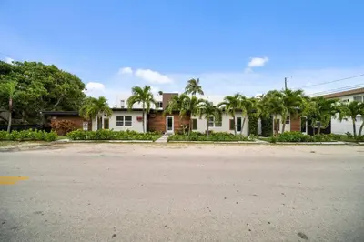 an empty street in front of a house with palm trees at Las Olas Newly Renovated Coastal 1BR Near Beach in Fort Lauderdale