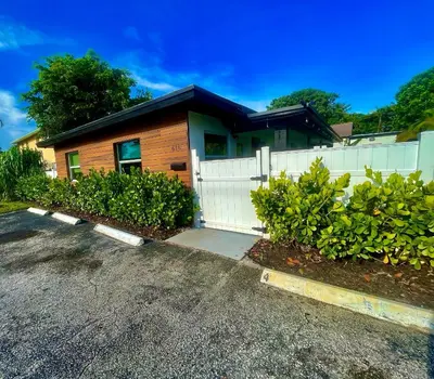 a house with a white fence and a driveway at SuaveMauve Las Olas Beach in Fort Lauderdale