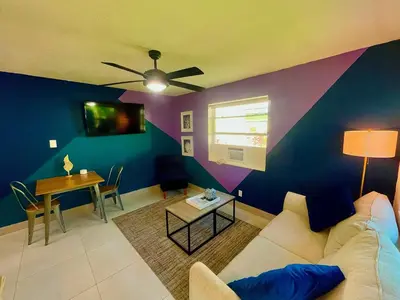 a living room with a couch and a table at SuaveMauve Las Olas Beach in Fort Lauderdale