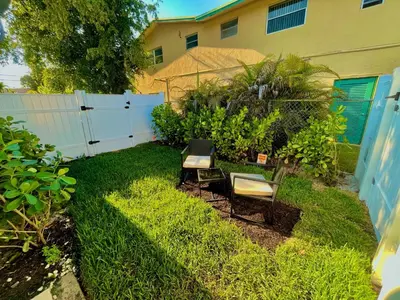 two chairs sitting in the grass in a backyard at SuaveMauve Las Olas Beach in Fort Lauderdale