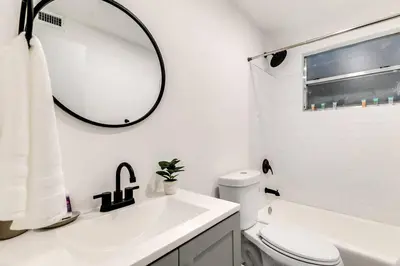 a white bathroom with a sink and a mirror at Airport Loft 1b full kitchen Virg 10 in Miami