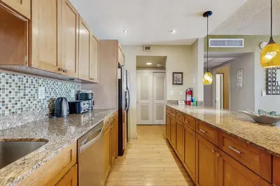 a large kitchen with wooden cabinets and a sink at Ocean Reserve 1607 in Miami Beach