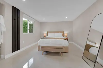 a white bedroom with a bed and a window at Casa Copal: Relaxing Beach House in Hollywood