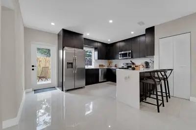 a large kitchen with a table and a refrigerator at Casa Copal: Relaxing Beach House in Hollywood