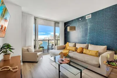 a living room with a couch and a table at Amazing Pool - Apartment with Balcony and Gym in Hallandale Beach