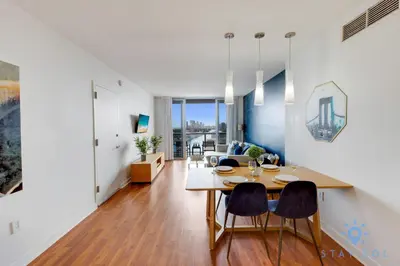 a dining room and living room with a table and chairs at Infinite View Balcony - Amazing Pool - Gym in Hallandale Beach