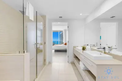 a white bathroom with two sinks and a shower at Oceanfront Balcony Enjoy Endless Views Hot Tub in Hollywood