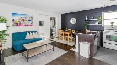 a living room with a blue couch and a kitchen at Brickell Pearl Cozy House Beach 10 min Location in Miami