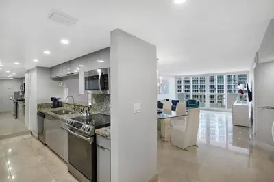 a kitchen with stainless steel appliances and a living room at Wildest Dreams Penthouse! Dreams Do Come True in Miami