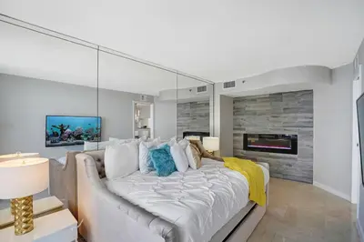 a bedroom with a large white bed and a fireplace at Wildest Dreams Penthouse! Dreams Do Come True in Miami