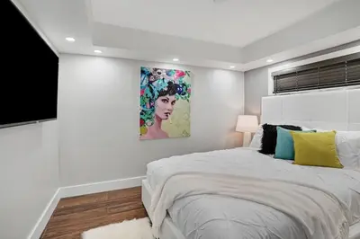 a white bedroom with a large bed and a painting at The Bond - OO7 Vibes and Penthouse Water Views! in Miami