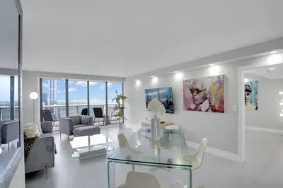 a living room with a glass table and a couch at Superstar! Penthouse with Water and Park Views! in Miami