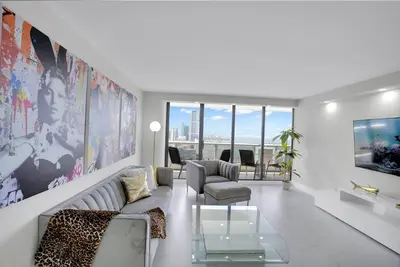 a living room with a couch and a table at Superstar! Penthouse with Water and Park Views! in Miami