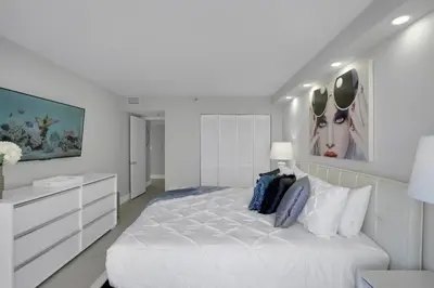 a white bedroom with a large white bed with pillows at Superstar! Penthouse with Water and Park Views! in Miami