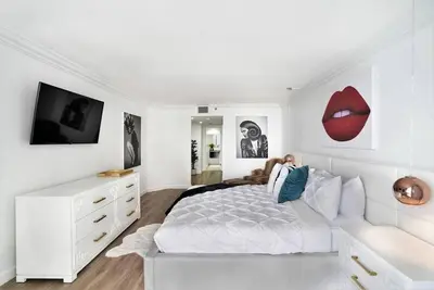 a bedroom with a white bed and a white dresser at Magic City! Water And Park Views! in Miami
