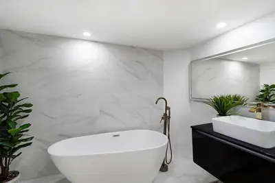 a bathroom with a large white tub and a sink at Magic City! Water And Park Views! in Miami