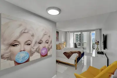 a living room with a painting of two women with donuts at Paradise Found! Miami Skyline and Water Views! in Miami