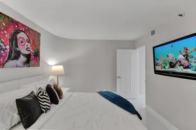 a bedroom with a bed and a large painting on the wall at Paradise Found! Miami Skyline and Water Views! in Miami
