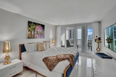 a white bedroom with a bed and a large window at Paradise Found! Miami Skyline and Water Views! in Miami