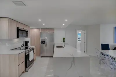 a large kitchen with white counter tops and stainless steel appliances at Elevate! Water and Park Views in Miami
