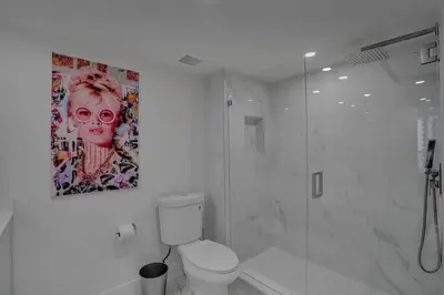 a bathroom with a toilet and a painting on the wall at Elevate! Water and Park Views in Miami
