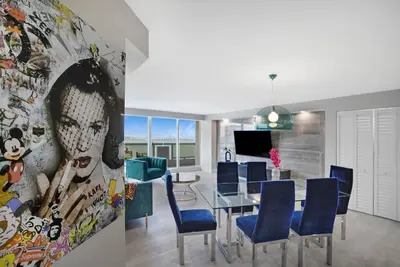 a dining room with a table and blue chairs at Unforgettable! Water & Park Views, 4 Bedrooms! in Miami
